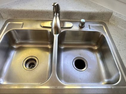 After: the same double kitchen sink polished bright, with clear drains and an even finish.