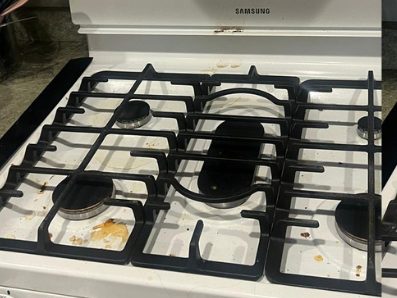 Before: a gas cooktop with burnt-on spills across the enamel and around the burner rings.