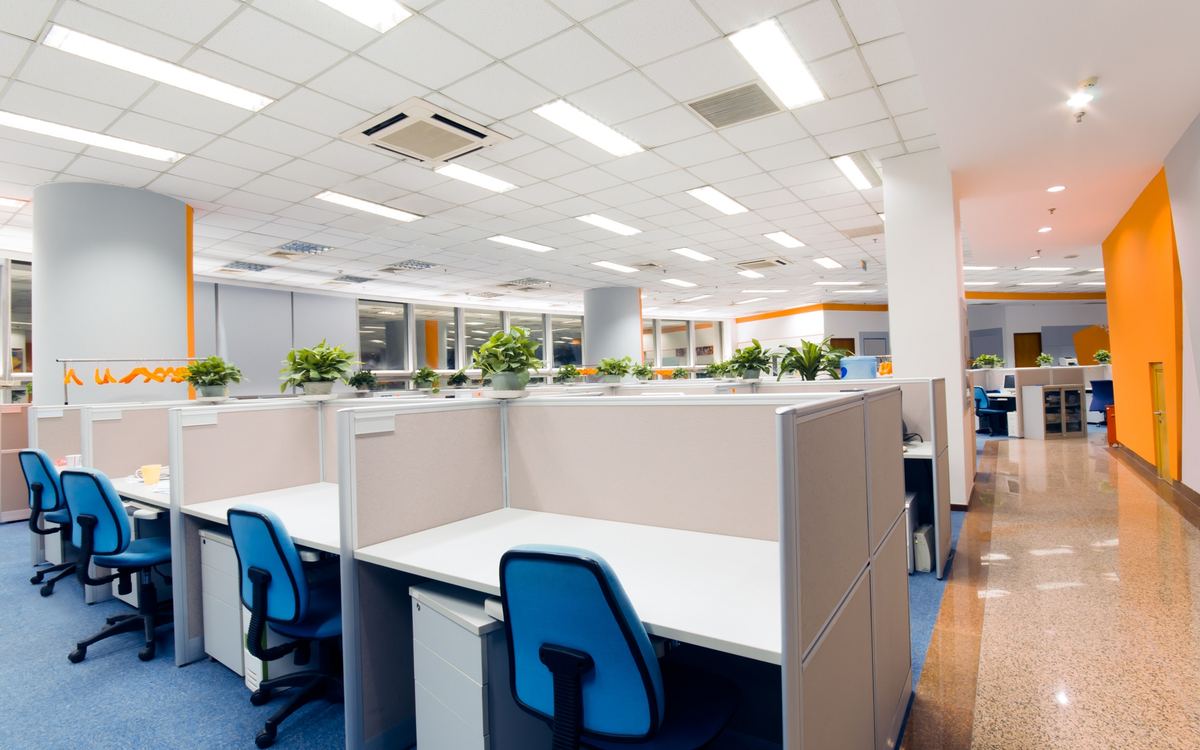 Open-plan office with rows of desks, chairs and a polished corridor floor